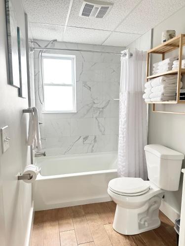 a white bathroom with a toilet and a shower at Abellona Inn & Suites in Old Orchard Beach