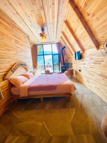 a bedroom with a large bed in a wooden wall at SHATOBUNGALOV in Çamlıhemşin