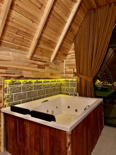 a large bath tub in a room with wooden ceilings at SHATOBUNGALOV in Çamlıhemşin