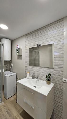 bagno con lavandino e specchio di Apartamento Adriano a Santiponce