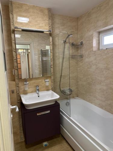 La salle de bains est pourvue d'un lavabo, d'une douche et d'une baignoire. dans l'établissement Page3 Apartament, à Târgovişte