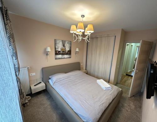 - une chambre avec un lit et un lustre dans l'établissement Page3 Apartament, à Târgovişte