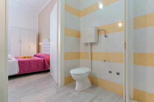a small bathroom with a toilet and a bed at CalaBisso in Calasetta