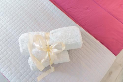 a white towel with a bow on a bed at CalaBisso in Calasetta