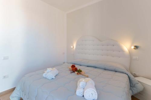 a bedroom with a white bed with towels on it at CalaBisso in Calasetta