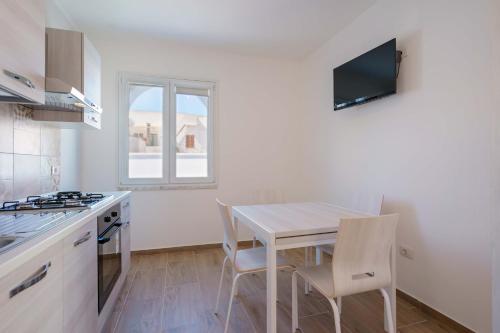 a kitchen with a table and chairs in a room at CalaBisso in Calasetta