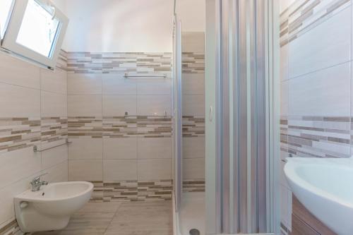 a bathroom with a shower and a toilet and a sink at CalaBisso in Calasetta