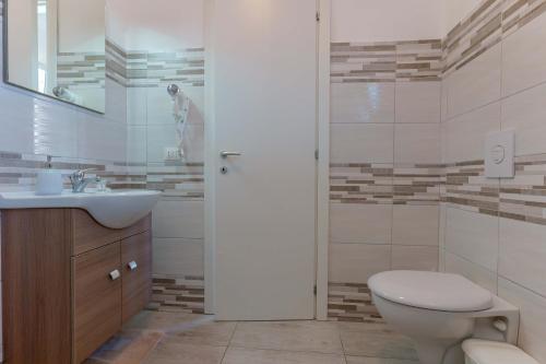 a bathroom with a toilet and a sink and a shower at CalaBisso in Calasetta