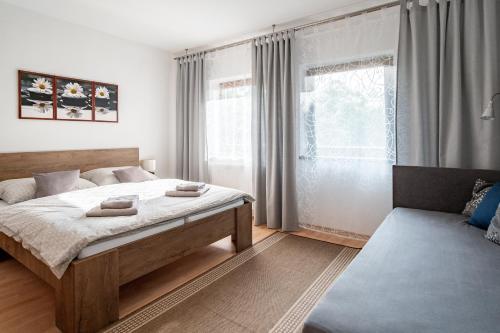 um quarto com uma cama grande e uma janela em Apartmány TriMM em Uherské Hradiště