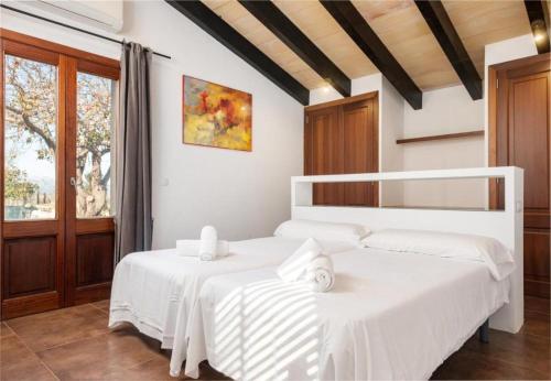 2 letti bianchi in una camera con finestra di Villa Vernisa 454 a Can Picafort