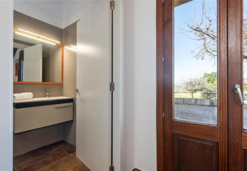 bagno con porta, lavandino e specchio di Villa Vernisa 454 a Can Picafort