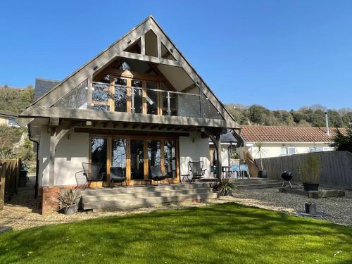 a house with a large window on a yard at Woodland View Stunning Spacious 5 Bedroom Holiday Home in Saint Lawrence