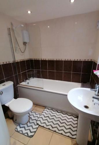 a bathroom with a toilet and a tub and a sink at Centralized Private 4 BR House at Hanley with Free Parking in Etruria