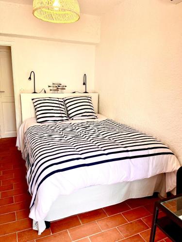 une chambre avec un lit à rayures noires et blanches dans l'établissement Les Collines, à Sainte-Maxime