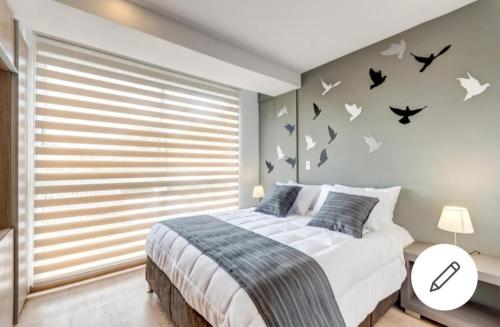 1 dormitorio con 1 cama con pájaros en la pared en Loft Contador, en Bogotá