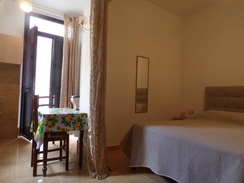 um quarto com uma cama, uma cadeira e uma janela em LA CASA DEL LIMONE - Via Umberto 477 em Roccalumera