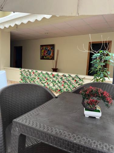 a table with two chairs and a vase of flowers on it at Aparta Hotel Roma in Santo Domingo