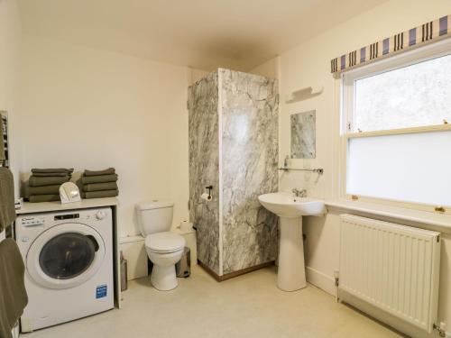 a bathroom with a washing machine and a toilet and a sink at 30 Union Street in Kirkcudbright