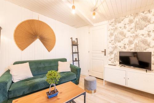雷恩的住宿－LIK APPARTS - La Courrouze Rennes，客厅配有绿色沙发和电视