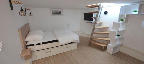 Habitación pequeña con cama y escalera en T2 prés de la mer - Six Fours Les Plages, en Six-Fours-les-Plages