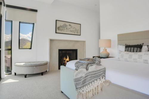 a white bedroom with a bed and a fireplace at Stone Hollow 1884 townhouse in Park City