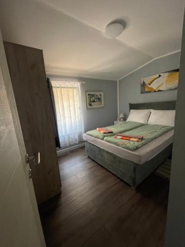 a small bedroom with a bed and a window at Golden BIS 2, Subotica in Subotica