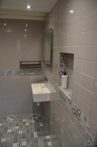 The Annexe @ Woodland في Bury: حمام أبيض مع حوض ومرآة