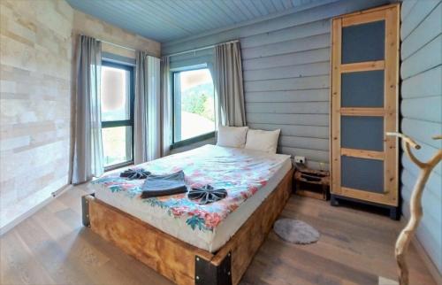 1 dormitorio con 1 cama en una habitación con ventanas en Vila Costin Fundata en Fundăţica