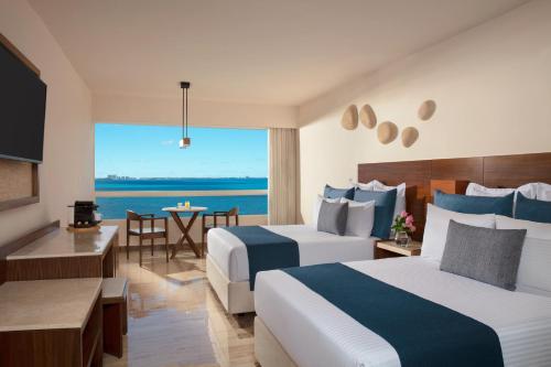 Cette chambre d'hôtel comprend deux lits et offre une vue sur l'océan. dans l'établissement Dreams Sands Cancun Resort & Spa, à Cancún