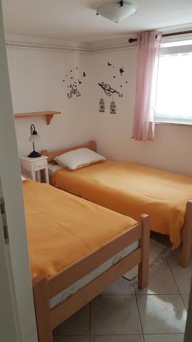 two beds in a small room with a window at Apartment Branka in Labin
