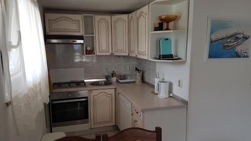 a small kitchen with white cabinets and a sink at Apartment Branka in Labin