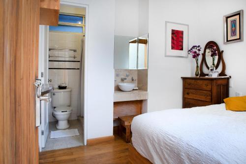 a bedroom with a bed and a bathroom with a sink at Stella Bed & Breakfast in Mexico City