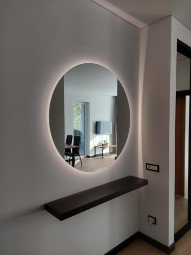 a round mirror on the wall of a living room at Birštono Perlas apartamentai in Birštonas