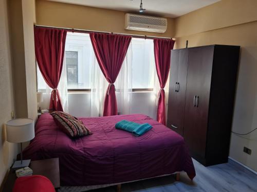 1 dormitorio con cama morada frente a una ventana en Monoambiente a 300 metros del Obelisco en Buenos Aires