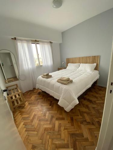 1 dormitorio con 1 cama blanca grande y suelo de madera en Hermoso con la mejor ubicación en Buenos Aires