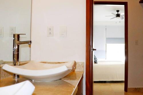 a bathroom with a white sink and a mirror at New Condo with Pool, Gym, A/C, WiFi, King Size bed in Cancún