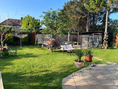a yard with a fence and some chairs and plants at Cozy room with full bathroom in Dagenham
