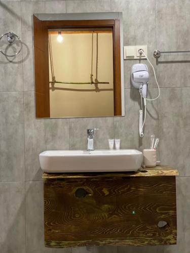 La salle de bains est pourvue d'un lavabo et d'un miroir. dans l'établissement Hotel Ailama Mestia, à Mestia