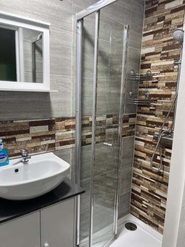 a bathroom with a shower and a sink at Cozy room with full bathroom in Dagenham