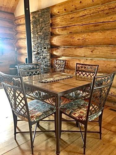 a wooden table with two chairs and a wooden wall at Sportsman Lodge Melrose MT in Melrose