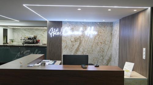 an office with a reception desk and a marble wall at Hôtel Restaurant Clément ADER in Muret