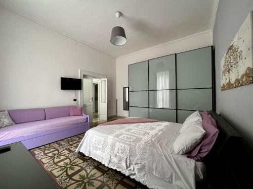ターラントにあるAlsimica Apartmentのベッドルーム(紫色のベッド1台、ソファ付)
