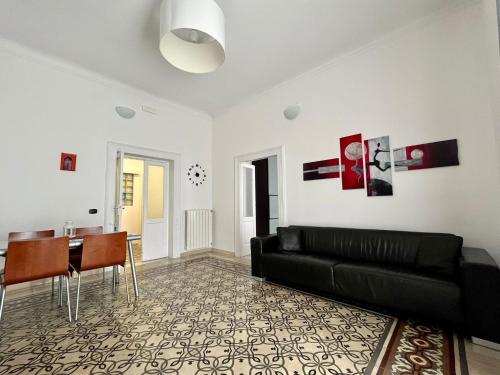 ターラントにあるAlsimica Apartmentの黒いソファとテーブルのあるリビングルーム
