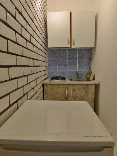 a kitchen with a white table and a brick wall at Apartments Vejo in Korčula