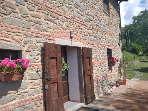 a brick building with an open door and flowers at Villa Belvedere in Pieve Fosciana