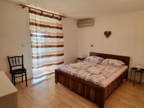 1 dormitorio con 1 cama, 1 silla y 1 ventana en Apartment Melanie, en Skrbčići