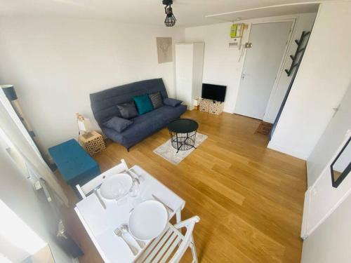 un salon avec un canapé bleu et une table dans l'établissement Le studio Aigle - proche quais rive droite - 249, à Rouen