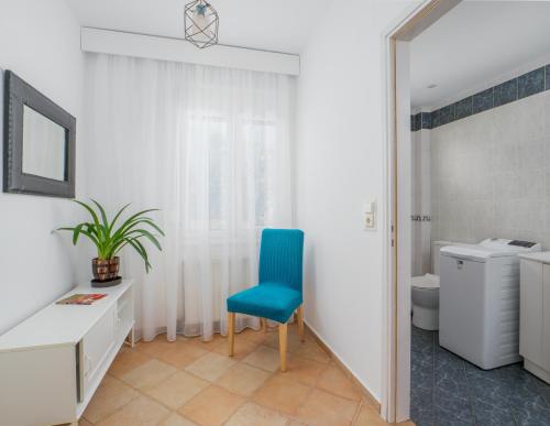 een badkamer met een blauwe stoel en een toilet bij Wild Pear Villa in Agia Pelagia
