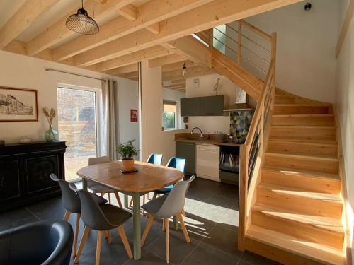 Una cocina y un comedor con mesa y sillas de madera. en La cabane du banc José, en Le Rozel
