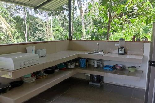 eine Küche mit einem Waschbecken und einem Fenster in der Unterkunft Almendra de Montaña in Puerto Viejo